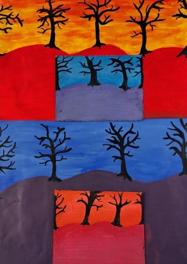 Silhouettes of winter trees against blue and orange skies