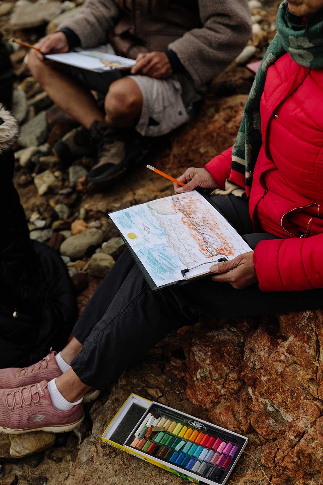 Close-up of walker on the beach drawing a beach scene in dull light and cold weather