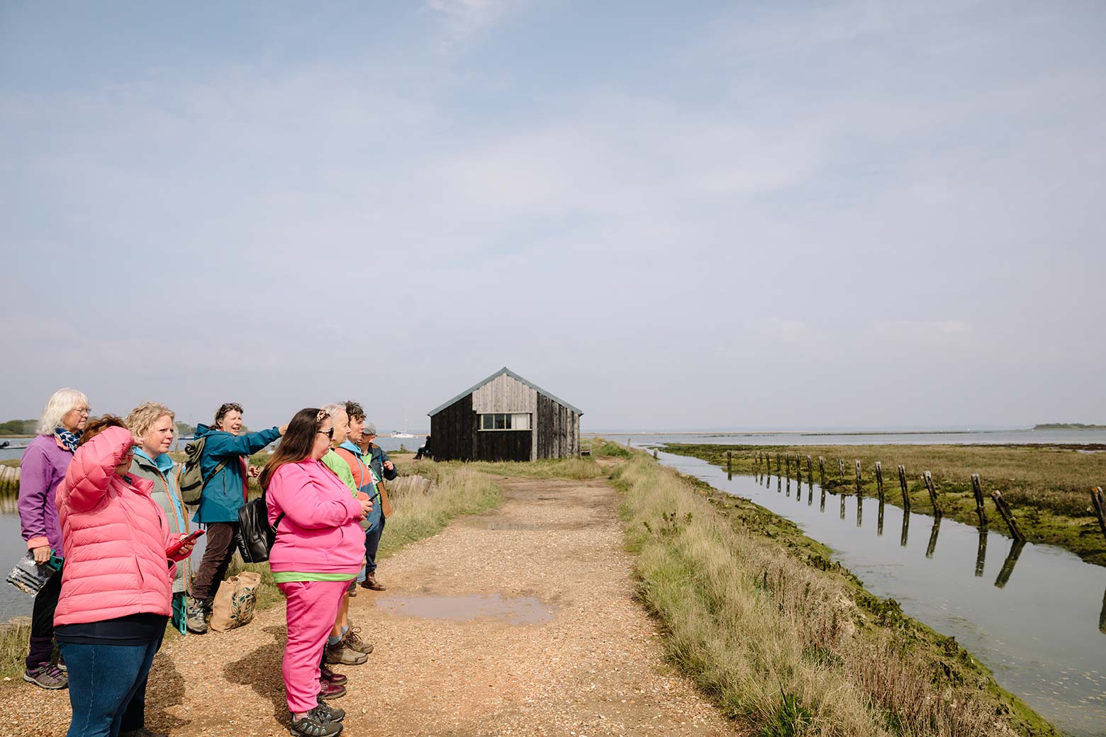 Photo of group at Newtown Creek on path overlooking the water all looking in the same direction at wildlife in the distance