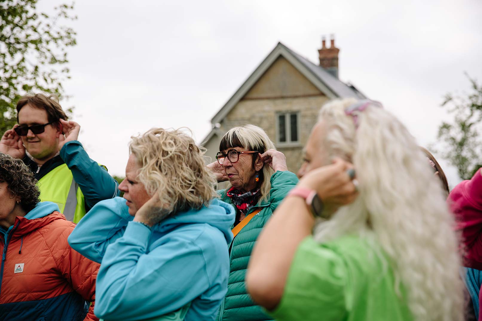 Photo of group listening to bird song with their hands cupping their ears