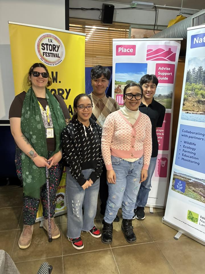 Writer and four young people in front of nature and storytelling banners