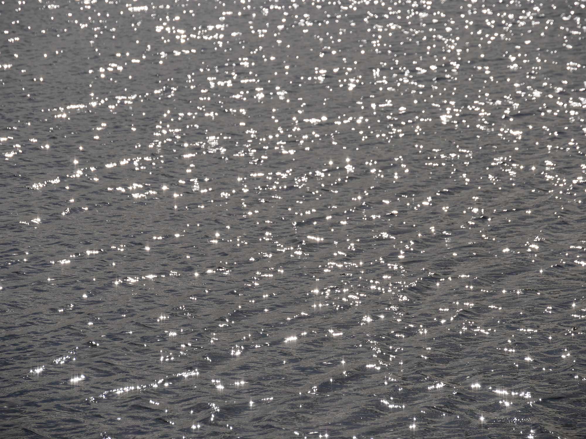Sunlight reflecting on the water, grey blue colour water